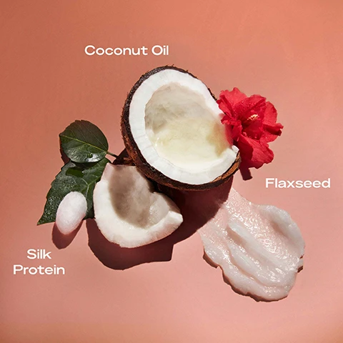 Image 1 - An open coconut with its white flesh, coconut oil, a sprig of leaves, a red flower, and a small piece of coconut on a pink background with visible text labeling Coconut Oil, Flaxseed, and Silk Protein.
Image 2 - Image of a jar of SheaMoisture Coconut & Hibiscus Curl Enhancing Smoothie on a peach background, with text that reads Great for curly and coily hair, reduces frizz, defines curls and enhances shine, perfect for twist-out, braid-out or wash-and-go styles, and smooths hair for a soft, silky feel.