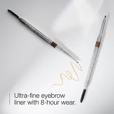 Image 1 - Image shows two ultra-fine eyebrow liners with a brush on one end, accompanied by a swatch of the product and text reading Ultra-fine eyebrow liner with 8-hour wear.
Image 2 - Image shows two strokes of brow liner in varying brown shades against a white background, with icons indicating precision brow liner and the text smudge resistant.
Image 3 - A close-up of a womans face with a focus on her eye and eyebrow, showing her applying eyebrow makeup with a pencil, and the visible text reads Available in 6 shades.
Image 4 - A woman applying mascara while looking in a mirror, wearing a white lab coat over a green top, with text overlay stating The Clinique Eye Safety Promise, Ophthalmologist tested, Safe for sensitive eyes, Safe for contact lens wearers, Ashley Brissette, MD, MSc, FRCSC, Cliniques Guiding Ophthalmologist.
Image 5 - A close-up image of a clear glass bottle with a ribbed background, listing items it is free of: fragrance, phthalates, and parabens.