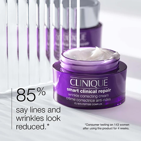 Image 1 - A close-up of a purple jar of Clinique Smart Clinical Repair wrinkle correcting cream, with text stating 85% say lines and wrinkles look reduced and a note about consumer testing on 143 women after using the product for 4 weeks.
Image 2 - Image showing two close-up sections of skin labeled Before at the top and After at the bottom, with text stating Panelist’s individual results (12 weeks of daily use). Individual results will vary.
Image 3 - A blurred white background with three words listed vertically: strength, smooth, hydrate, with icons representing strength, smoothness, and hydration.
Image 4 - A purple background displays a list titled Free of, with check marks indicating the absence of fragrance and oil beneath it.