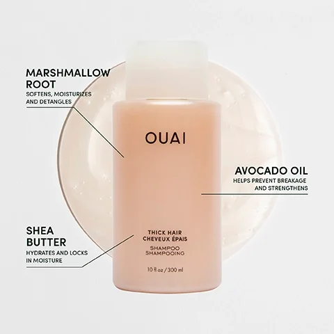 A bottle of OUAI thick hair shampoo, placed on a round dish, with labels pointing out key ingredients: marshmallow root, avocado oil, and shea butter, along with their benefits and the text indicating the bottle size as 10 fl oz or 300 ml.
