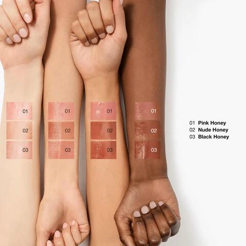 Image 1 - Four forearms with diverse skin tones display swatches of three lip products numbered 01, 02, and 03, with corresponding text on the right listing 01 Pink Honey, 02 Nude Honey, 03 Black Honey. Image 2 - Three lipsticks in silver tubes are shown vertically with honey dripping on them: a dark black cherry shade labeled Black Honey, a pink shade labeled Pink Honey, and a nude brown shade labeled Nude Honey.  Image 4 - A close-up portrait of three smiling women with the text Models wear Nude Honey. Image 2 - Close-up of cosmetic swatches in shades of pink and red with a liquid drop icon and the text add sheer color.
