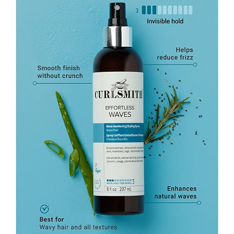 Image 1 - A dark brown Curlsmith Effortless Waves Wave Awakening Styling Spray bottle with a silver top and a white and blue label is shown on a light blue background, surrounded by fresh aloe vera leaves with water droplets and a sprig of rosemary with scattered seeds, featuring visible text on the bottle that reads CURLSMITH EFFORTLESS WAVES Wave Awakening Styling Spray Wavy Hair Spray Coiffant Embellisseur De Ondules Cheveux Bouclés linseed extract, chia extract, squalane, aloe vera, rosemary, sage, resurection flower extrait de lin, extrait de chia, squalane, aloe vera, romarin, sauge, plante de la résurrection Vegan 3 INVISIBLE HOLD / TENUE INVISIBLE 8 fl oz 237 mL, and additional text annotations on the background stating 3 Invisible hold, Smooth finish without crunch, Helps reduce frizz, Best for Wavy hair and all textures, and Enhances natural waves. Image 2 - The image shows a side-by-side comparison of two Curlsmith Effortless Waves styling spray bottles, the old design on the left with an orange label and the new design on the right with a blue label, separated by an arrow, accompanied by a Same Great Product New Look badge, with both bottles displaying Curlsmith, Effortless Waves, Wave Awakening Styling Spray, 8 fl oz 237 mL, Vegan, and the old bottle additionally stating invisible hold while the new bottle states visible hold 3.